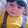 baby, child, sunglasses, yellow_shirt, car_seat, straps, face, head, eyes, infant, cute, portrait, closeup, person, clothing, seatbelt, indoors, soft_light, expression, toddler