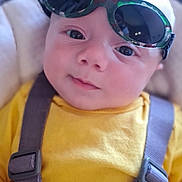 Loris a rejoint le concours — aidez-le/la à gagner de superbes lots ! baby, child, sunglasses, yellow_shirt, car_seat, straps, face, head, eyes, infant, cute, portrait, closeup, person, clothing, seatbelt, indoors, soft_light, expression, toddler