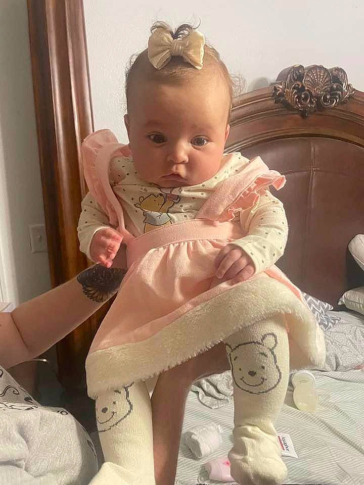 Adriana joined the competition — help win amazing prizes! baby, baby_toddler_clothing, blond, cheek, comfort, embellishment, eyelash, head, human_body, human_leg, iris, knee, person, pink, ruffle, sitting, skin, sleeve, textile, thigh