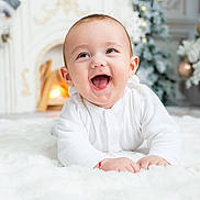 Patrick joined the competition — help win amazing prizes! baby, infant, smiling, white_clothing, blanket, fireplace, christmas_tree, holiday_decor, indoors, cute, happy, toddler, face, child, warmth, festive, cozy, holiday, celebration, portrait