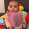 baby, infant, child, purple_bib, floral_onesie, plush_seat, soft_toy, clip, indoor, couch, cute, expression, face, hand, sitting, clothing, comfort, young_child, portrait, person