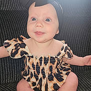 Calliope joined the competition — help win amazing prizes! baby, infant, child, smiling, headband, bow, leopard_print, dress, sitting, couch, indoor, cute, happy, blue_eyes, drool, skin, portrait, person, apparel, fabric