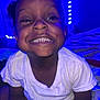 Brenynn joined the competition — help win amazing prizes! child, toddler, smiling, white_shirt, teeth, indoor, blue_light, bed, blanket, happy, cute, person, hair, skin, face, sitting, young_child, playful, cozy, portrait