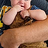 River joined the competition — help win amazing prizes! baby, child, infant, person, adult, arm, clothing, romper, dinosaur_pattern, smile, happy, holding, cute, fingers, face, skin, seated, casual, indoor, black_background
