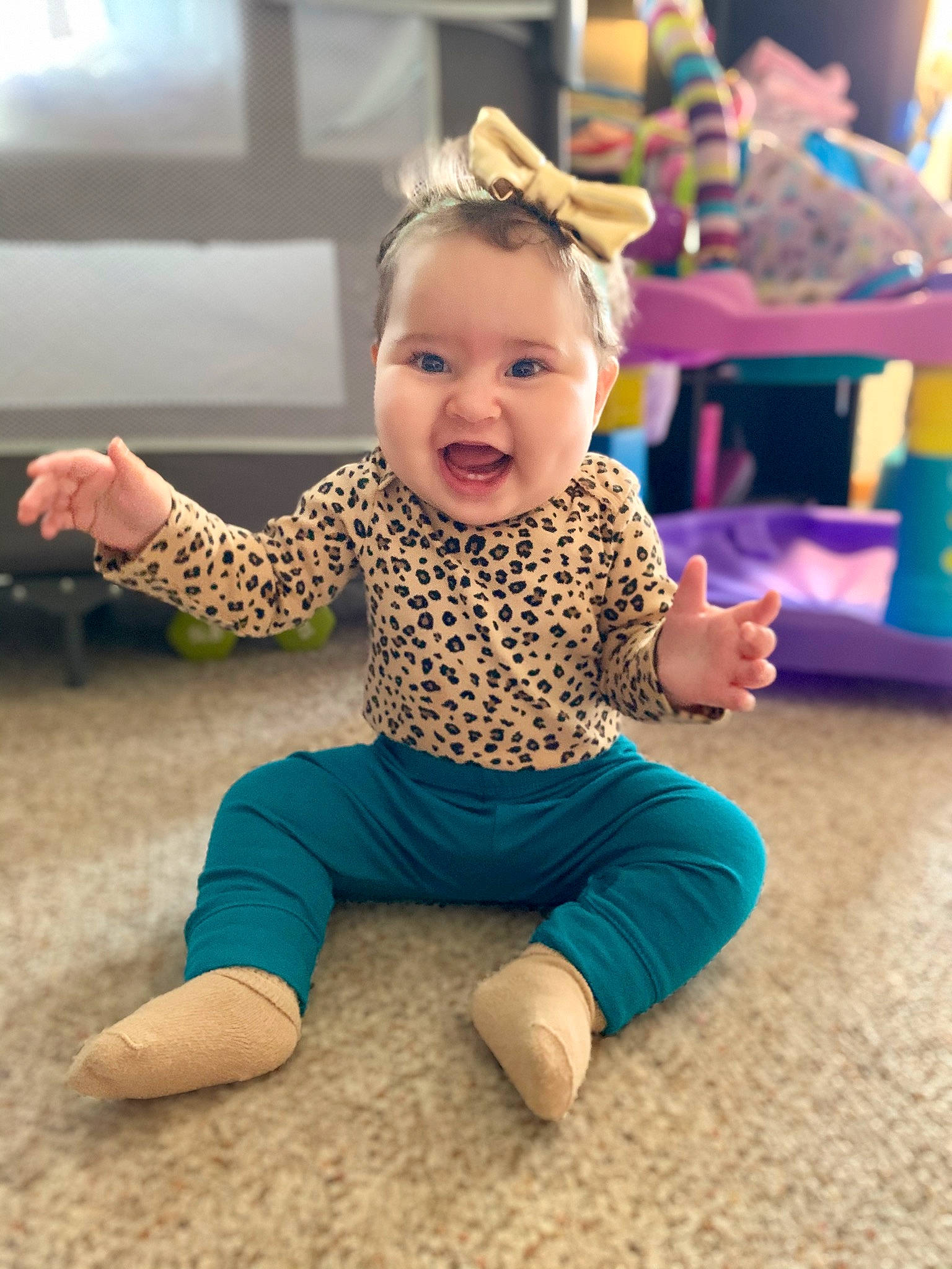 Elaïa joined the competition — help win amazing prizes! arm, baby, cheek, child, dress, face, facial_expression, floor, flooring, fun, happy, head, leisure, person, play, sitting, skin, sleeve, smile, toddler
