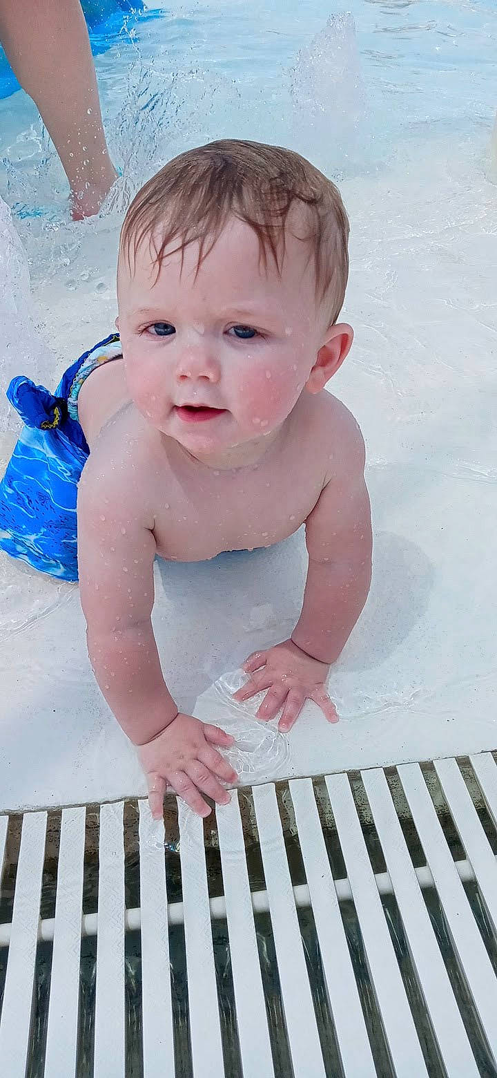 Jerry is registered to the contest to win money with this photo: arm, baby, baby_safety, baby_toddler_clothing, bathing, cheek, cradle, finger, hand, happy, human_body, infant_bed, organ, person, photograph, pink, skin, sleeve, thumb, toddler