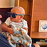 Anthony joined the competition — help win amazing prizes! adult, arm, artwork, baby, blanket, blue, casual, child, clothing, confused, curious, frame, furniture, holding, indoor, person, shelf, sunglasses, tattoo, teddy_bear_pattern