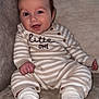 Joey joined the competition — help win amazing prizes! baby, smiling, striped_clothing, socks, couch, blanket, indoor, infant, happy, face, person, seated, cozy, plush, cute, pajamas, child, furniture, comfort, portrait
