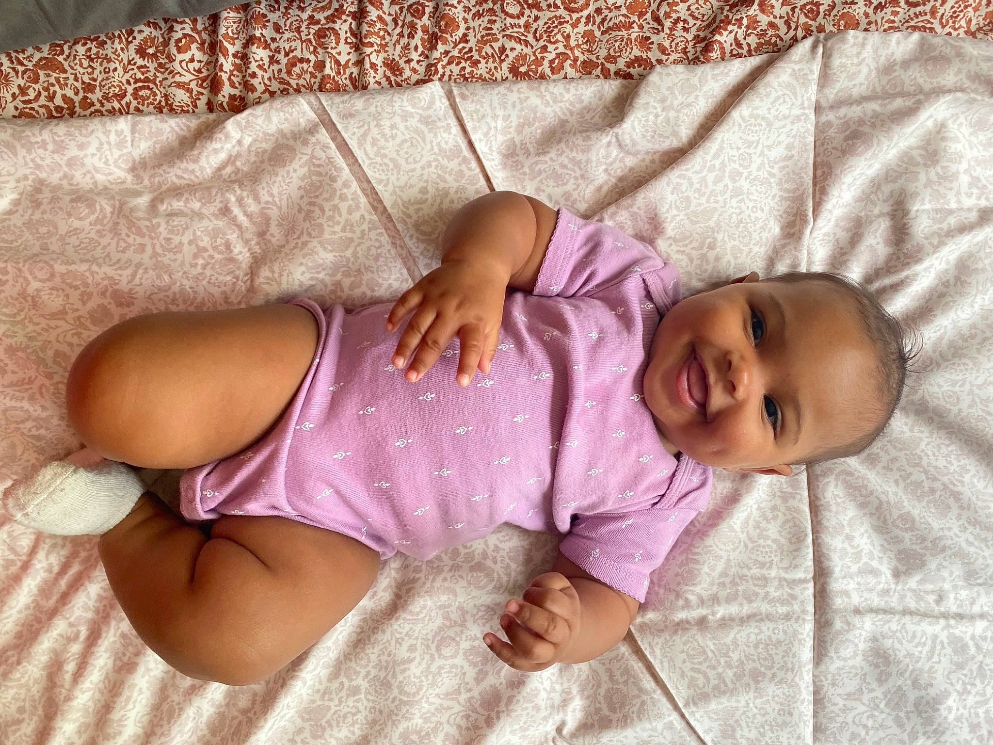 Londyn is registered to the contest to win money with this photo: baby, baby_safety, baby_sleeping, baby_toddler_clothing, child, comfort, finger, human_body, human_leg, joy, knee, leg, linens, pattern, person, pink, purple, skin, sleeve, smile