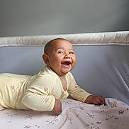 Neziya is registered to the contest to win money with this photo: baby, infant, smiling, tummy_time, crib, yellow_onesie, watermelon_prints, blanket, happy, cute, child, indoor, portrait, face, young_child, person, soft_lighting, baby_clothes, mesh_crib_sides, joyful
