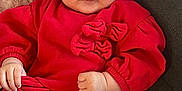 Ariana is registered to the contest to win money with this photo: baby, child, red_headband, red_top, white_leggings, bows, couch, indoor, cute, portrait, smiling, infant, clothing, hands, face, sitting, young_child, comfortable, fashion, adorable