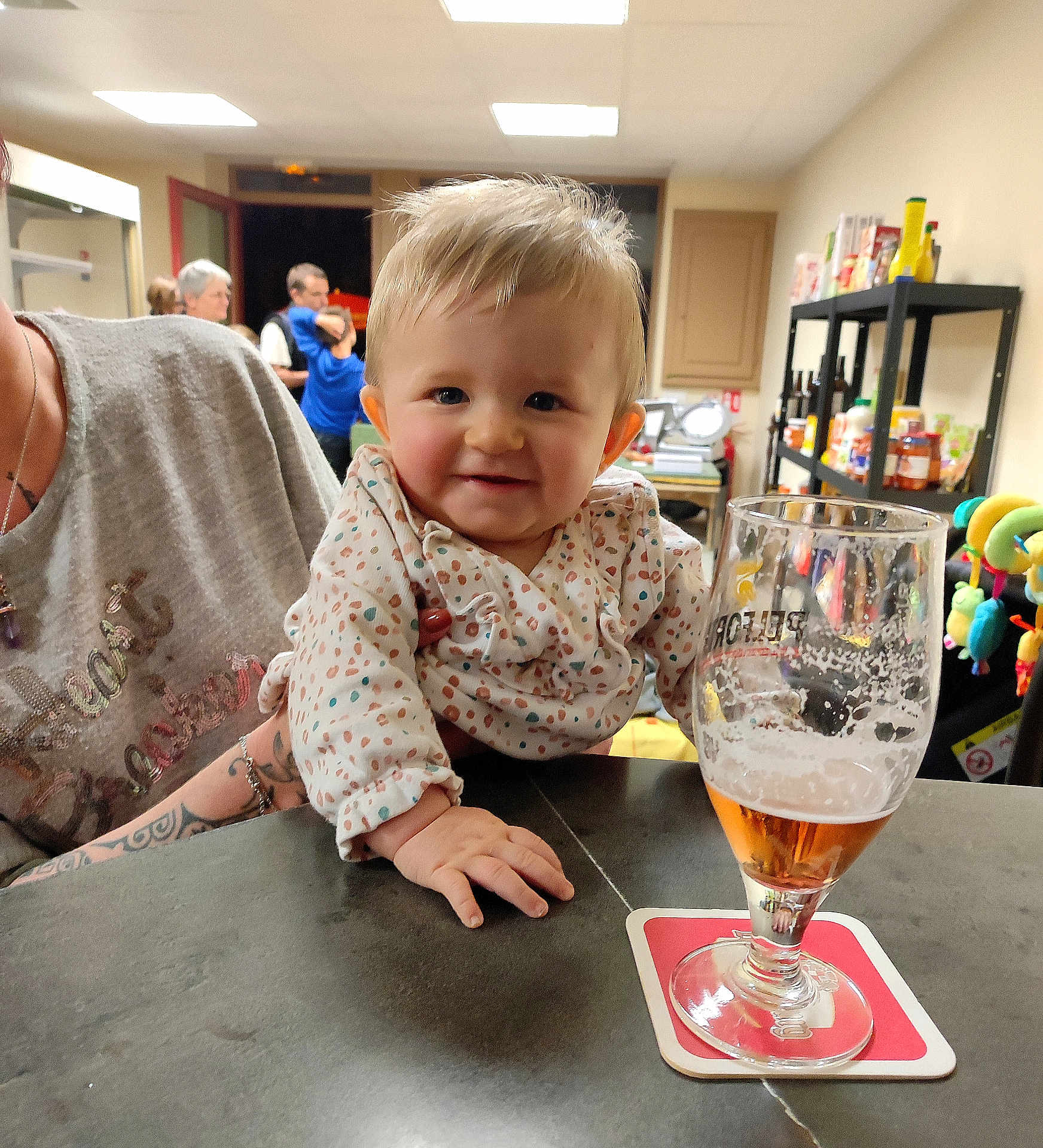 Kira a rejoint le concours — aidez-le/la à gagner de superbes lots ! baby, child, person, table, glass, beer, beverage, indoor, shelf, food, drink, adult, tattoo, clothing, smile, hand, face, room, people, background