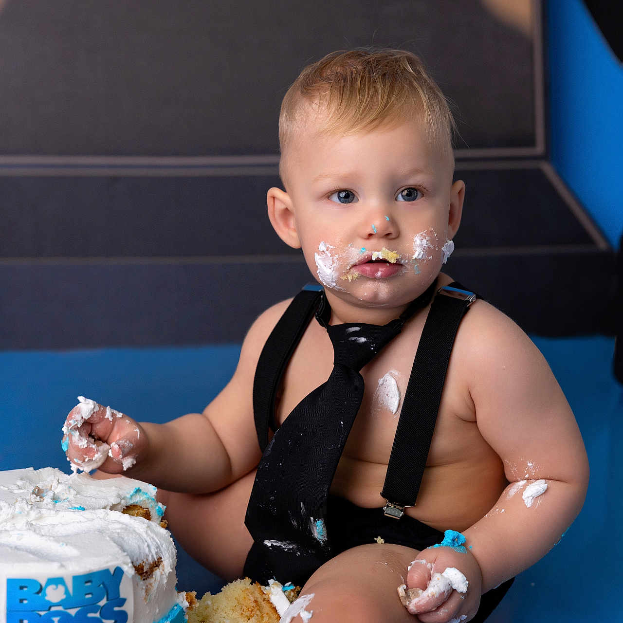 Kerem joined the competition — help win amazing prizes! baby, birthday, blue, cake, cake_smash, celebration, child, crumbs, cute, face, frosting, hands, indoor, messy, party, photography, smash, suspenders, tie, white