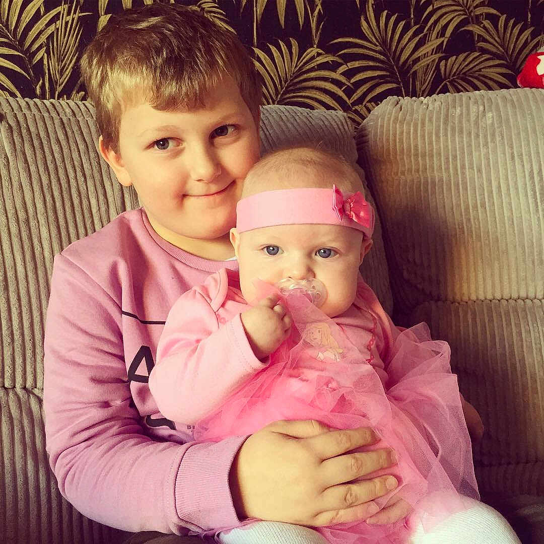 Theo joined the competition — help win amazing prizes! baby, cheek, child, daughter, eye, face, family, fun, happy, head, iris, joy, lap, lip, love, people, person, pink, sibling, sitting