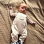 baby, infant, blanket, clothing, overalls, striped_sleeves, sneakers, footwear, lying_down, texture, fabric, cute, portrait, child, small, young, casual, comfortable, indoors, resting