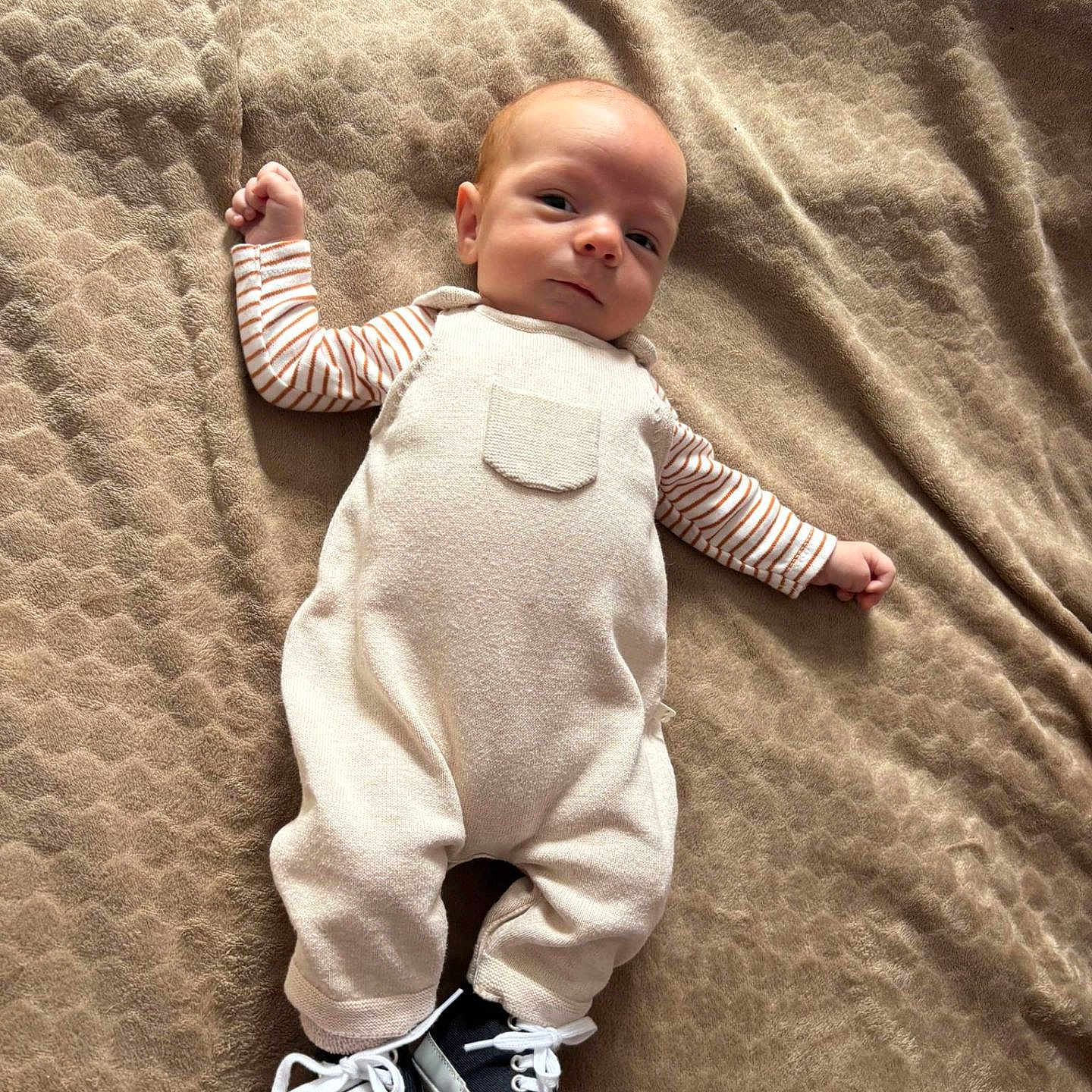 Noah participe au concours pour gagner de l'argent avec cette photo : baby, blanket, casual, child, clothing, comfortable, cute, fabric, footwear, indoors, infant, lying_down, overalls, portrait, resting, small, sneakers, striped_sleeves, texture, young