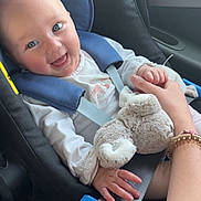 Louane participe au concours pour gagner de l'argent avec cette photo : baby, car_seat, blue_eyes, plush_toy, hand_holding, car_interior, smiling, child, seatbelt, clothing, person, infant, safety, cute, happy, parent, travel, seat, window, arm