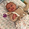 baby, infant, smiling, clothing, headband, blanket, pacifier, toy, giraffe, bottle, lotion, mattress, pattern, towel, nursery, person, cute, indoor, child, lying