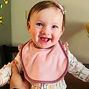 Abigail Aleksa is registered to the contest to win money with this photo: baby, infant, smiling, pink_bib, floral_pajamas, hand, smartwatch, indoor, butterfly_decorations, happy, child, cute, portrait, person, face, head, clothing, sitting, home, cheerful