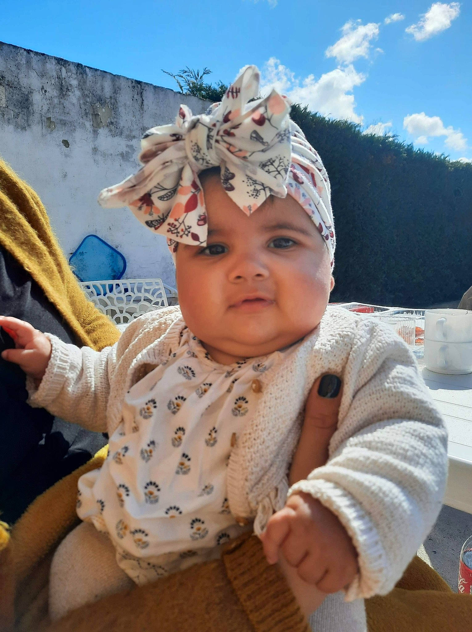 Nélya a rejoint le concours — aidez-le/la à gagner de superbes lots ! baby, baby_toddler_clothing, cap, child, fashion_accessory, fun, grass, happy, hat, headgear, headwear, jewellery, leisure, mountain, person, recreation, sitting, skin, sky, sun_hat