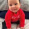 baby, child, smile, red_sweatshirt, spiderman, sitting, bed, pillow, white_socks, black_pants, indoors, cute, happy, infant, portrait, hand, foot, cozy, young_child, playful