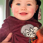 Nathanaël participe au concours pour gagner de l'argent avec cette photo : baby, child, smiling, cap, maroon_shirt, cartoon_character, hand, indoor, portrait, happy, cute, blue_eyes, person, clothing, face, young_child, holding, casual, headwear, expression