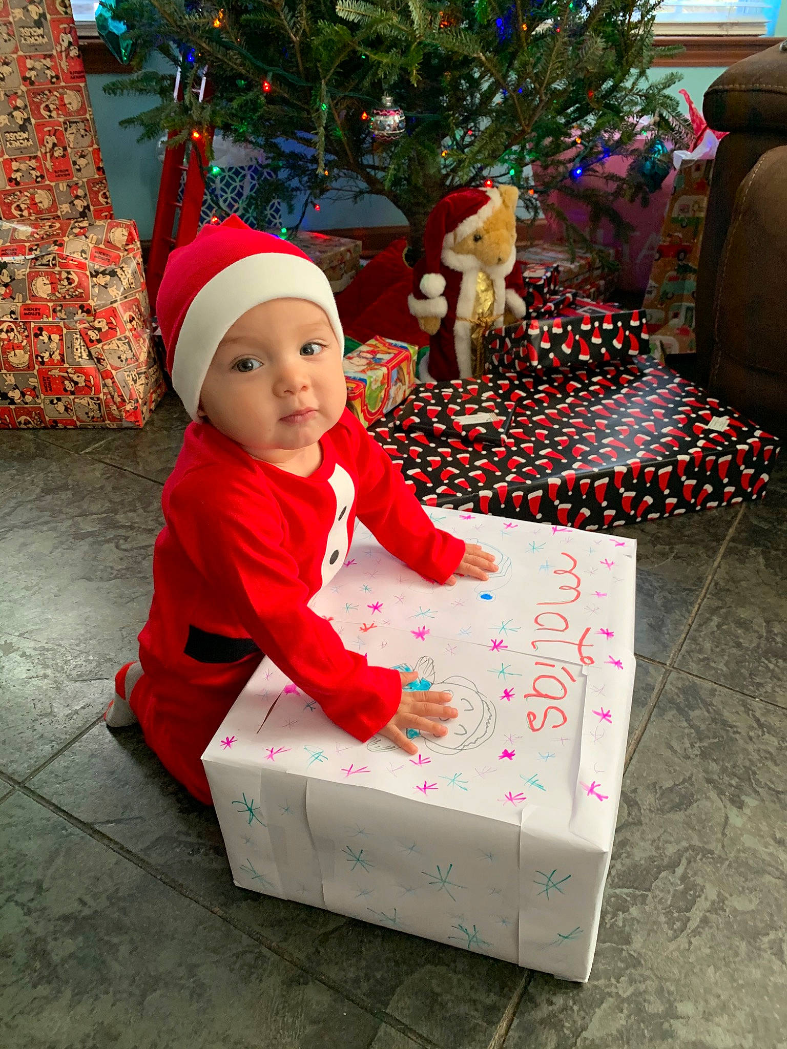Matias is registered to the contest to win money with this photo: child, christmas, christmas_decoration, christmas_eve, christmas_tree, event, fictional_character, headwear, holiday, interior_design, person, santa_claus, toddler