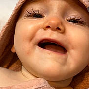Tessa a rejoint le concours — aidez-le/la à gagner de superbes lots ! baby, smiling, close_up, towel, pink, face, child, happy, skin, portrait, eyelashes, cute, infant, mouth_open, soft_texture, blanket, indoors, cheeks, young, warm