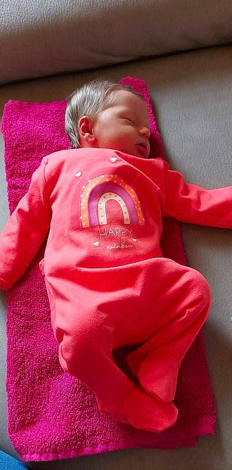 Hanaé a rejoint le concours — aidez-le/la à gagner de superbes lots ! baby, baby_products, baby_toddler_clothing, carmine, cheek, child, comfort, face, flooring, head, linens, magenta, person, pink, play, sitting, skin, sleeve, sportswear, t_shirt