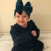 Zeliha joined the competition — help win amazing prizes! baby, black_pants, blue_eyes, bow, child, cute, giraffe_illustration, happy, headwear, indoor, infant, long_sleeves, plaid_clothing, portrait, ruffle, sitting, smile, striped_mattress, velvet, white_sock