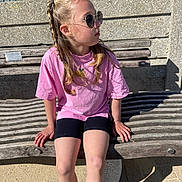 Zeliha joined the competition — help win amazing prizes! child, girl, braided_hair, sunglasses, pink_shirt, black_shorts, bench, outdoor, sunlight, shadow, concrete, wood, casual, sitting, relaxed, daytime, fashion, portrait, young, cool