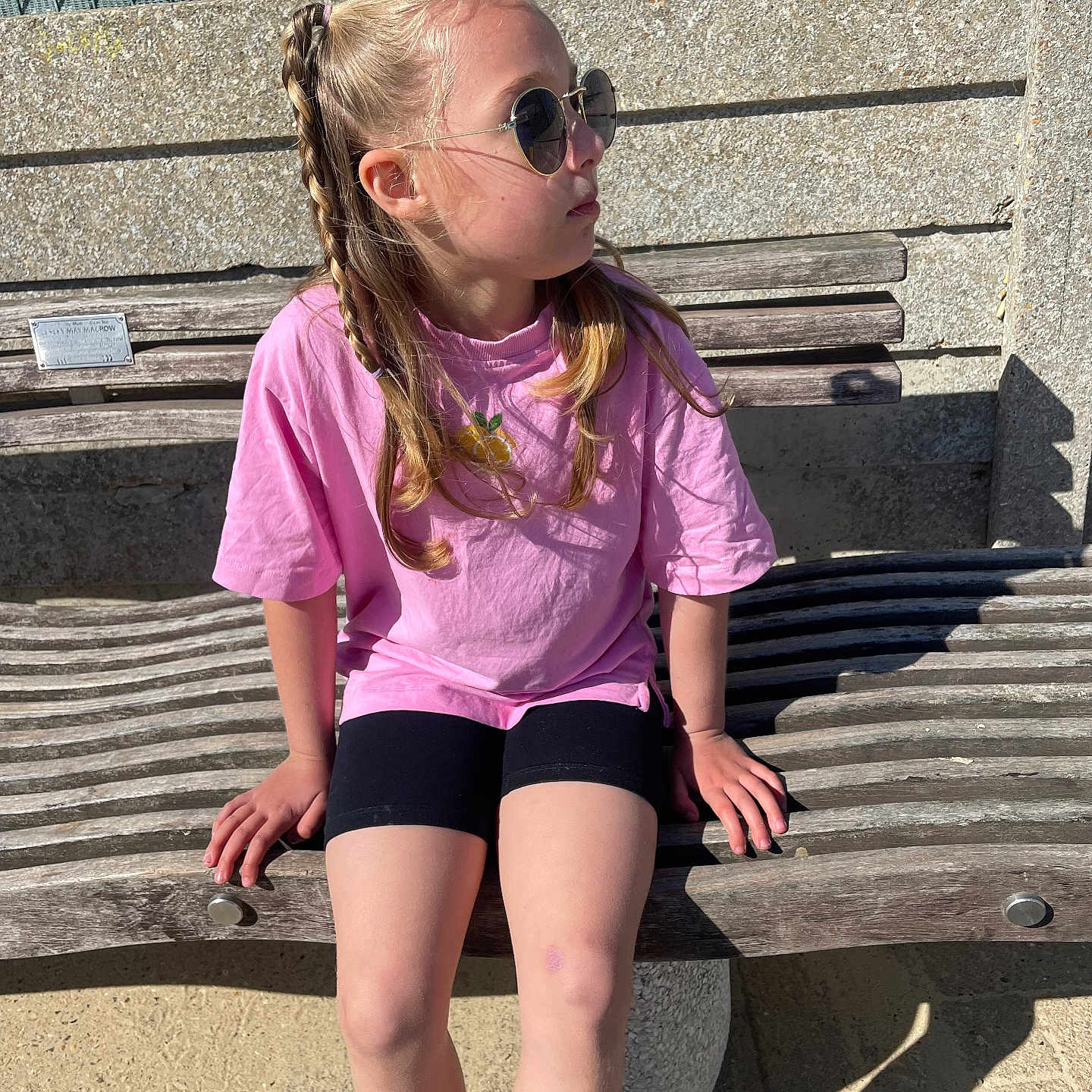 Zeliha joined the competition — help win amazing prizes! child, girl, braided_hair, sunglasses, pink_shirt, black_shorts, bench, outdoor, sunlight, shadow, concrete, wood, casual, sitting, relaxed, daytime, fashion, portrait, young, cool
