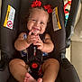 Sanova joined the competition — help win amazing prizes! baby, child, car_seat, smile, red_bow, curly_hair, hands, feet, straps, sitting, cute, happy, infant, indoors, clothing, face, person, seat, safety, adorable