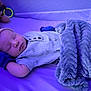 baby, sleeping, crib, blanket, hat, mittens, toy, plush, purple_light, infant, face, peaceful, cozy, bed, child, soft_texture, resting, clothing, indoor, comfort