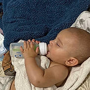 Alejandro is registered to the contest to win money with this photo: baby, bottle, feeding, towel, blanket, sleeping, child, hand, face, ear, skin, indoors, comfort, resting, cute, infant, young, peaceful, nap, soft