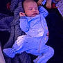 baby, sleeping, onesie, blanket, plush_toy, giraffe, infant, child, soft_texture, cozy, bedtime, cute, peaceful, indoor, portrait, footed_pajamas, star_pattern, resting, toddler, comfort