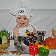 Dean participe au concours pour gagner de l'argent avec cette photo : apron, baby, bell_pepper, chef_hat, cherry_tomatoes, child, cooking_pot, eggplant, green_pepper, infant, portrait, pumpkin, red_pepper, smiling, stainless_pot, studio_background, vegetables, wooden_spoons, yellow_pepper, zucchini