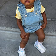 Keilani is registered to the contest to win money with this photo: braided_hair, casual_clothing, child, concrete_steps, curious_expression, cute, daylight, denim_overalls, fashion, hair_clips, outdoor, portrait, sitting, small_earrings, sneakers, sunflower_pattern, toddler, urban, white_socks, young_child