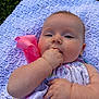 baby, child, infant, blanket, hand, face, outdoor, grass, pink_bow, clothing, cute, lying_down, soft_texture, knitted, expression, skin, person, young, closeup, summer
