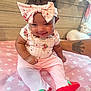 Diem is registered to the contest to win money with this photo: baby, infant, child, pink_clothing, headband, bow, curly_hair, smiling, sitting, blanket, stars_pattern, plush_toys, tattoo, arm, indoor, cute, portrait, happy, soft_toys, star_pattern
