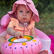 Lyanna participe au concours pour gagner de l'argent avec cette photo : baby, child, pink_hat, sunhat, inflatable_chair, inflatable_ring, outdoor, grass, greenery, summer, cute, infant, baby_clothing, baby_toy, person, sitting, face, feet, hand, closeup