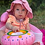 baby, child, pink_hat, sunhat, inflatable_chair, inflatable_ring, outdoor, grass, greenery, summer, cute, infant, baby_clothing, baby_toy, person, sitting, face, feet, hand, closeup