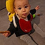 Lyanna a rejoint le concours — aidez-le/la à gagner de superbes lots ! baby, child, infant, sitting, floor, red_bib, yellow_backpack, plush_toy, cookie, clothing, indoors, head, face, eyes, hand, legs, gray_pants, curious_expression, toy, carpet
