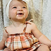 Sophia is registered to the contest to win money with this photo: accessories, baby, babylaughing, blonde, clothing, dress, face, hair, happy, hat, head, headband, jewelry, laughing, person, photography, portrait, sitting, sleeve, smile