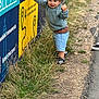 Morgan joined the competition — help win amazing prizes! child, toddler, hat, grass, signage, rock, sidewalk, sneaker, outdoor, smile, casual_clothing, shorts, sweater, road, playing, daylight, person, young_child, happy, nature