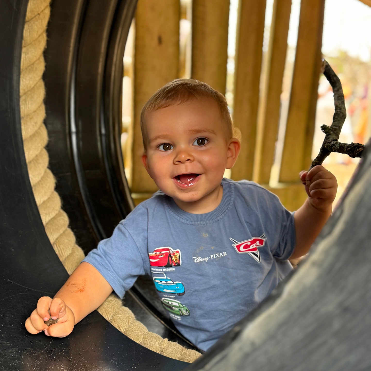 Morgan is registered to the contest to win money with this photo: Cars, Disney, Pixar, adventure, blue_shirt, child, cute, face, happy, outdoor, person, play, playground, rope, smiling, stick, toddler, toy, tunnel, wood