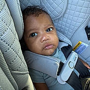 Anthony is registered to the contest to win money with this photo: baby, car_seat, child, infant, seatbelt, safety, quilted_fabric, pout, curious, strapped_in, clothing, closeup, indoors, person, portrait, young_child, cute, head, face, seat