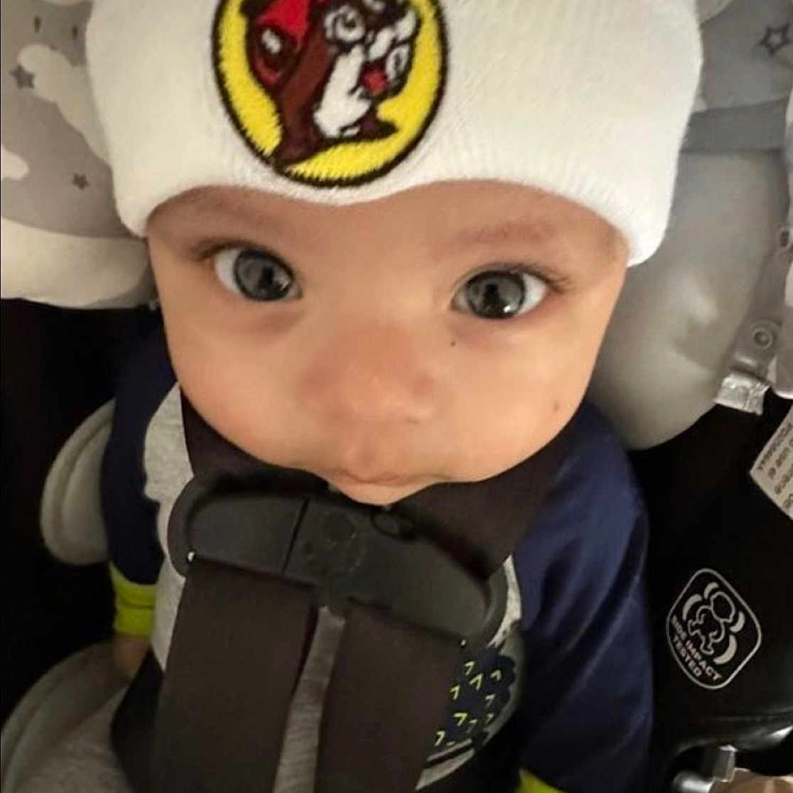 Lenzo joined the competition — help win amazing prizes! baby, beanie, car_seat, cartoon_patch, child, close_up, clothing, cute, fabric_pattern, gray_background, hands, harness, hat, infant, large_eyes, logo_patch, portrait, seat_belt, sitting, star_pattern