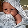 baby, towel, hooded_towel, face, skin, eyes, arm, soft_texture, indoor, close_up, child, person, newborn, wrapped, cozy, portrait, infant, cute, snug, bath_time