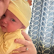 Arthur joined the competition — help win amazing prizes! baby, adult, hand, yellow_hat, yellow_clothing, striped_pants, curtain, pattern, closeup, face, skin, holding, indoor, person, newborn, ring, jewelry, soft_light, portrait, cuddle